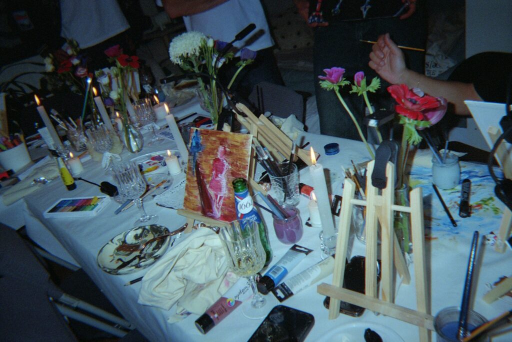 Table de peinture vue de dessus : pinceaux, fleurs et verres