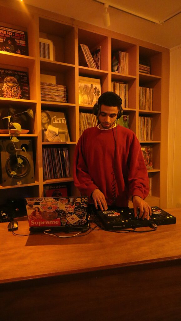 DJ à ses platines devant une bibliothèque